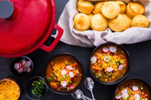 Turkey chili garnished with fresh radishes, green onions and cheddar cheese.