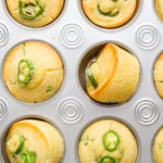Flat lay. Freshly baked cornbread muffins with spicy jalapeno pepper in muffin pan.