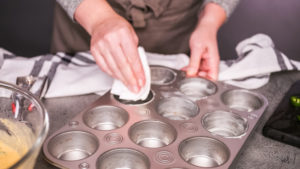 Cornbread muffins - Arina Photography Step by step. Greasing muffin pan for baking spicy jalapeno cornbread muffins.