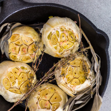 Roasted garlic - Arina Photography Roasted garlic spread recipe made with spices in cast iron skillet.