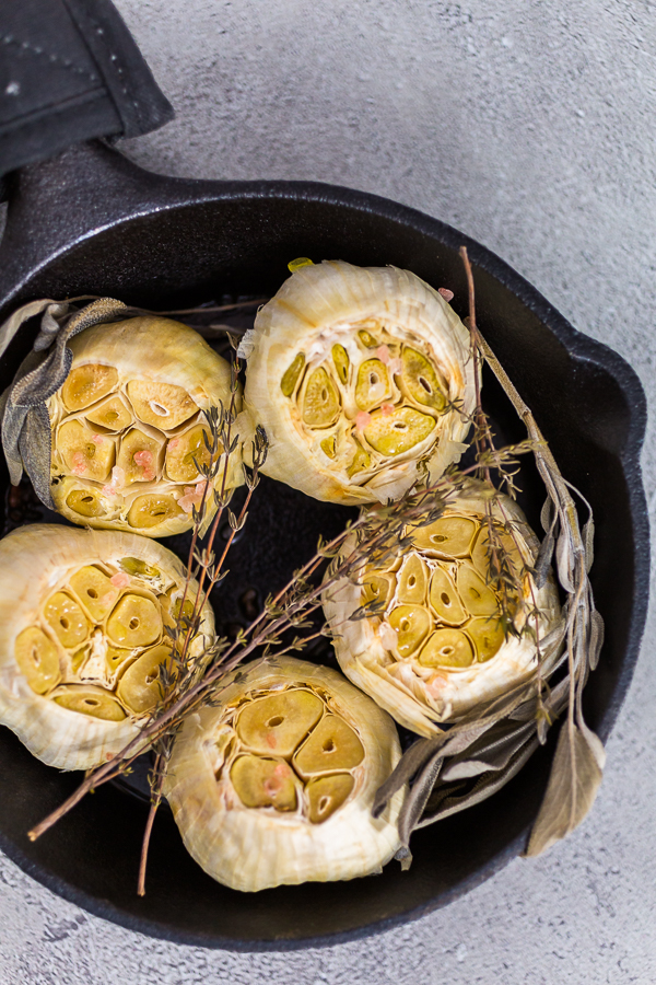 Roasted garlic - Arina Photography Roasted garlic spread recipe made with spices in cast iron skillet.
