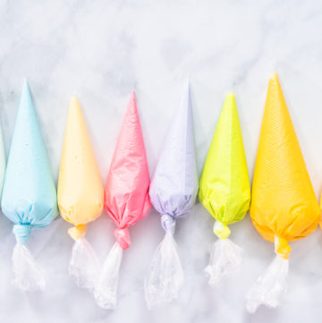 Royal icing - Arina Photography Flat lay. Piping bags with pastel color royal icing to decorate Easter sugar cookies.