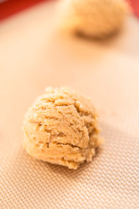 Peanut butter cookies - Arina Photography Cookie dough ball flattened with fork into traditional crisscross pattern