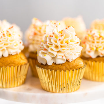 Pumpkin spice cupcake - Arina Photography Pumpkin spice cupcake with Italian buttercream and sprinkles on a cake stand.