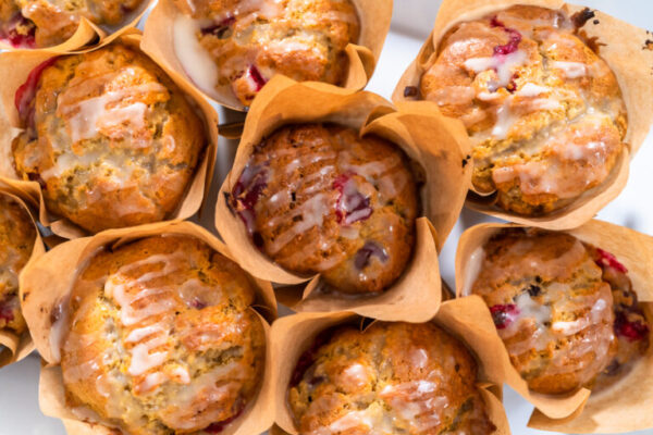 Freshly baked cranberry muffins in brown paper muffin cups.