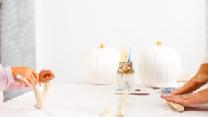 Step by step. Mother and daughter decorating Halloween craft pumpkin with unicorn theme.