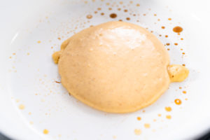 Pumpkin pancakes - Arina Photography Thick batter in a frying pan ready to be spread and cooked into a pancake.