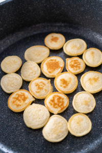 Mini pancake cereal - Arina Photography Golden mini pancakes cooking and browning on a skillet – perfectly flipped mini pancakes with even browning during cooking.