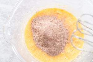 Wet and dry ingredients being mixed together in glass bowl