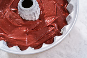 Bundt cake batter spread evenly in a greased bundt pan