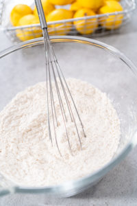 Lemon cranberry bundt cake - Arina Photography Mixing ingredients in a glass mixing bowl to prepare lemon cranberry bundt cake.
