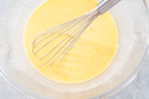 Lemon cranberry bundt cake - Arina Photography Mixing ingredients in a glass mixing bowl to prepare lemon cranberry bundt cake.