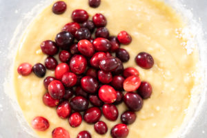 Lemon cranberry bundt cake - Arina Photography Mixing ingredients in a glass mixing bowl to prepare lemon cranberry bundt cake.