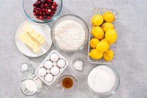 Lemon cranberry bundt cake - Arina Photography Flat lay. Ingredients in glass mixing bowls to prepare lemon cranberry bundt cake.