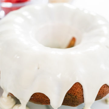 July 4th bundt cake - Arina Photography Vanilla-glazed Bundt cake with smooth, even drips cascading down the golden brown edges.