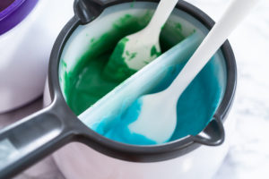 Melting chocolate chips in a candy melting pot to make chocolate mermaid tails.