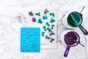 Flat lay. Removing chocolate mermaid tails from silicone molds.