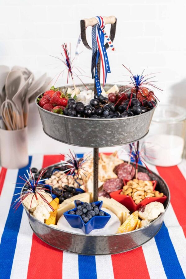July 4th Charcuterie board - Arina Photography Full view of assembled vertical charcuterie board with festive ribbon and cocktail picks.