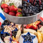 Strawberries, grapes, and yogurt raisins in a galvanized tray with blue star bowl.