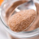 Cinnamon sugar in a glass mason jar on the marble surface.