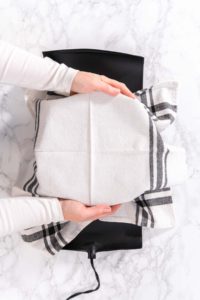 Covering dough bowl with kitchen towel for rising.