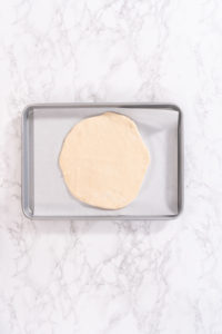 Cinnamon Dessert Pizza - Arina Photography Rolled out round of dough on baking sheet lined with parchment paper, ready for toppings.
