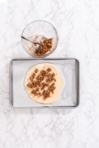 Cinnamon Dessert Pizza - Arina Photography Unbaked pizza dough topped with cinnamon mixture, ready for oven