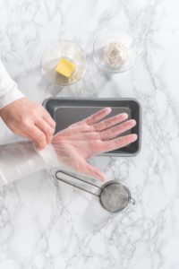 Greasing baking pan - Arina Photography