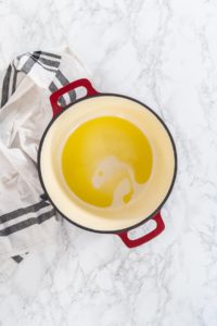 Flat lay. Cooking chicken noodle soup with kluski noodles in an enameled dutch oven.