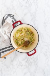 Flat lay. Cooking chicken noodle soup with kluski noodles in an enameled dutch oven.