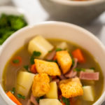 Serving split pea soup in ceramic soup bowls.