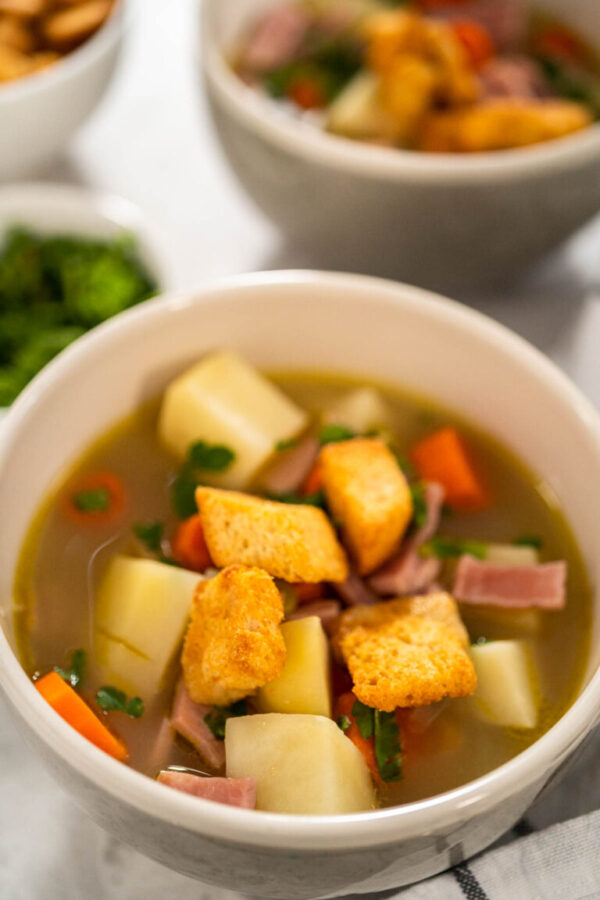 Serving split pea soup in ceramic soup bowls.