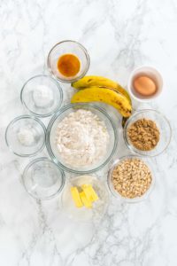 Flat lay. Measured ingredients in glass mixing bowls to bake banana oatmeal muffins.