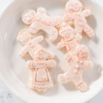 Chocolate gingerbread man with glitter on a white plate.
