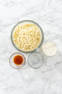 White chocolate ganache frosting - Arina Photography Flat lay. Measured ingredients in glass mixing bowls to make white chocolate ganache frosting.