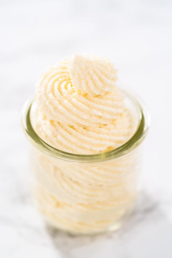 White chocolate ganache frosting in a small glass mason jar.