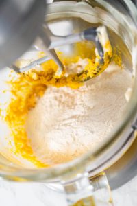 Lemon Wedge Cookies - Arina Photography Adding dry ingredients to wet mixture while beating in stand mixer.