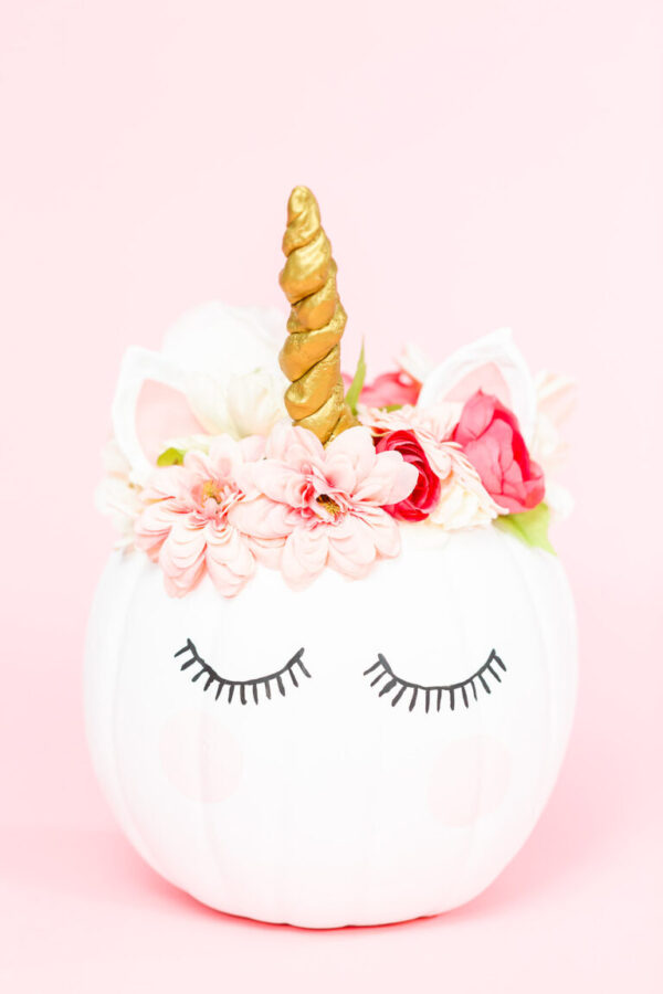Unicorn pumpkin - Arina Photography White unicorn pumpkin decorated with flowers on a pink background.