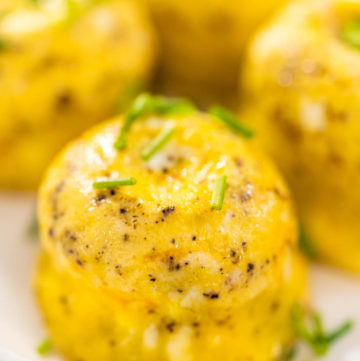 Egg bites - Arina Photography Serving egg bites garnished with fresh chives on a white plate.