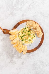 Butter board with vegetables and bread - Arina Photography Flat lay. Assembling butter board with vegetables and bread on a round wood cutting board.