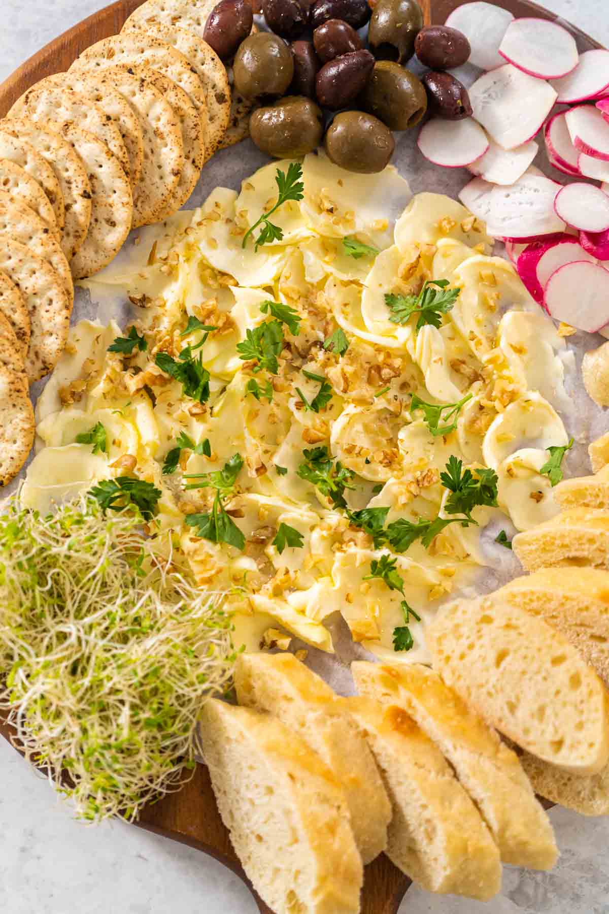 Butter board with vegetables and bread - Arina Photography Butter board with vegetables and bread on a round wood cutting board.