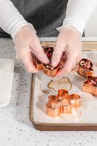 Christmas cookie-cutter peppermint fudge - Arina Photography Removing freshly made Christmas cookie-cutter peppermint fudge from cookie cutters.