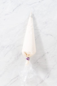 Gingerbread bundt cake with caramel filling - Arina Photography Flat lay. Transfering store-bought buttercream frosting into a piping bag to decorate gingerbread bundt cake with caramel filling.