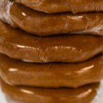 Discs of Classic Gingerbread Cookie Dough are stacked and wrapped in plastic, ready for chilling before being rolled out. Chilling helps the dough hold its shape, making it easier to cut into festive cookies.