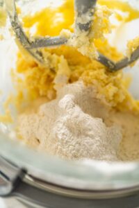 Dry flour mixture being gently incorporated into wet ingredients in a stand mixer to form a smooth sugar cookie dough.
