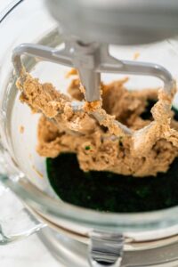 Vibrant Green Gingerbread Cookies for Festive Baking - Arina Photography The creamed butter and sugar mixture being combined with the vibrant green maple syrup blend in the mixer for Vibrant Green Gingerbread Cookies for Festive Baking.