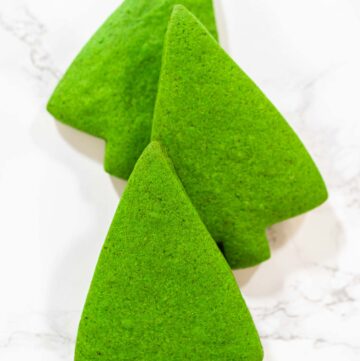 Festive Green Gingerbread Cookies for Holiday Baking - Arina Photography Three Green Gingerbread Cookies are arranged together in a standing formation, displaying their festive Christmas tree shape and vivid green color.