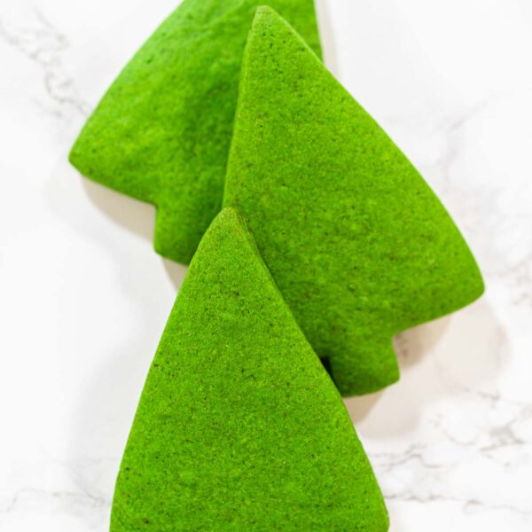 Festive Green Gingerbread Cookies for Holiday Baking - Arina Photography Three Green Gingerbread Cookies are arranged together in a standing formation, displaying their festive Christmas tree shape and vivid green color.