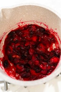 835-04925 - Arina Photography Cooked cranberries breaking down into a thick, chunky mixture in a saucepan, the first stage of making cranberry puree.