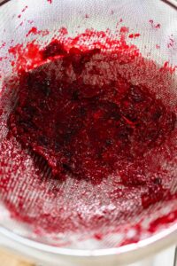 835-04933 - Arina Photography Strained cranberry solids left behind in a fine mesh sieve, showing the separation process for making smooth cranberry puree.